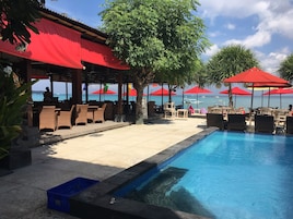 Una piscina al aire libre, sombrillas, sillones reclinables de piscina