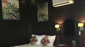 Habitación de hotel con dos camas, un escritorio, un espejo y un aire acondicionado.