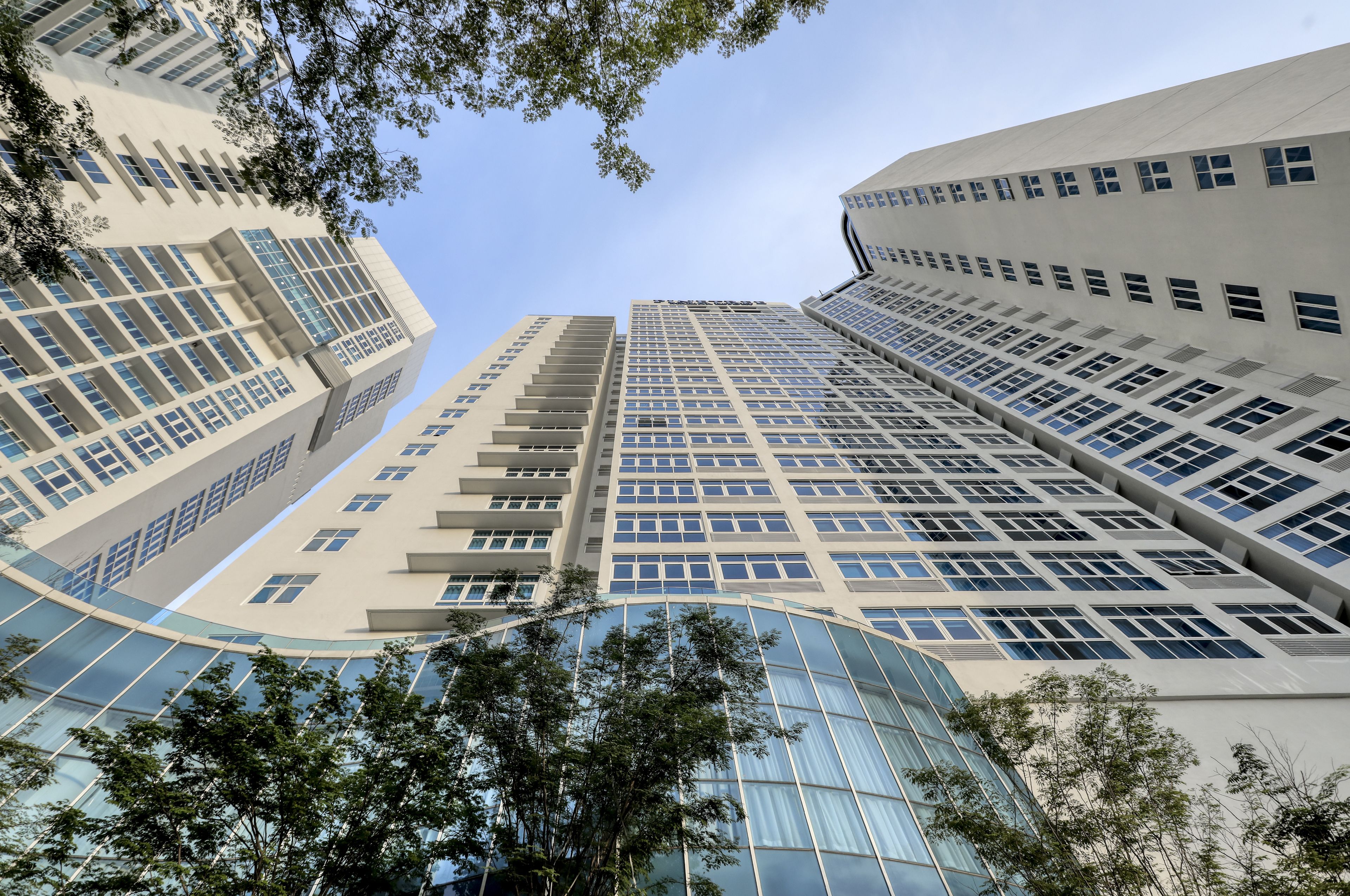 A high-rise building with multiple floors, large windows, and a curved glass facade.