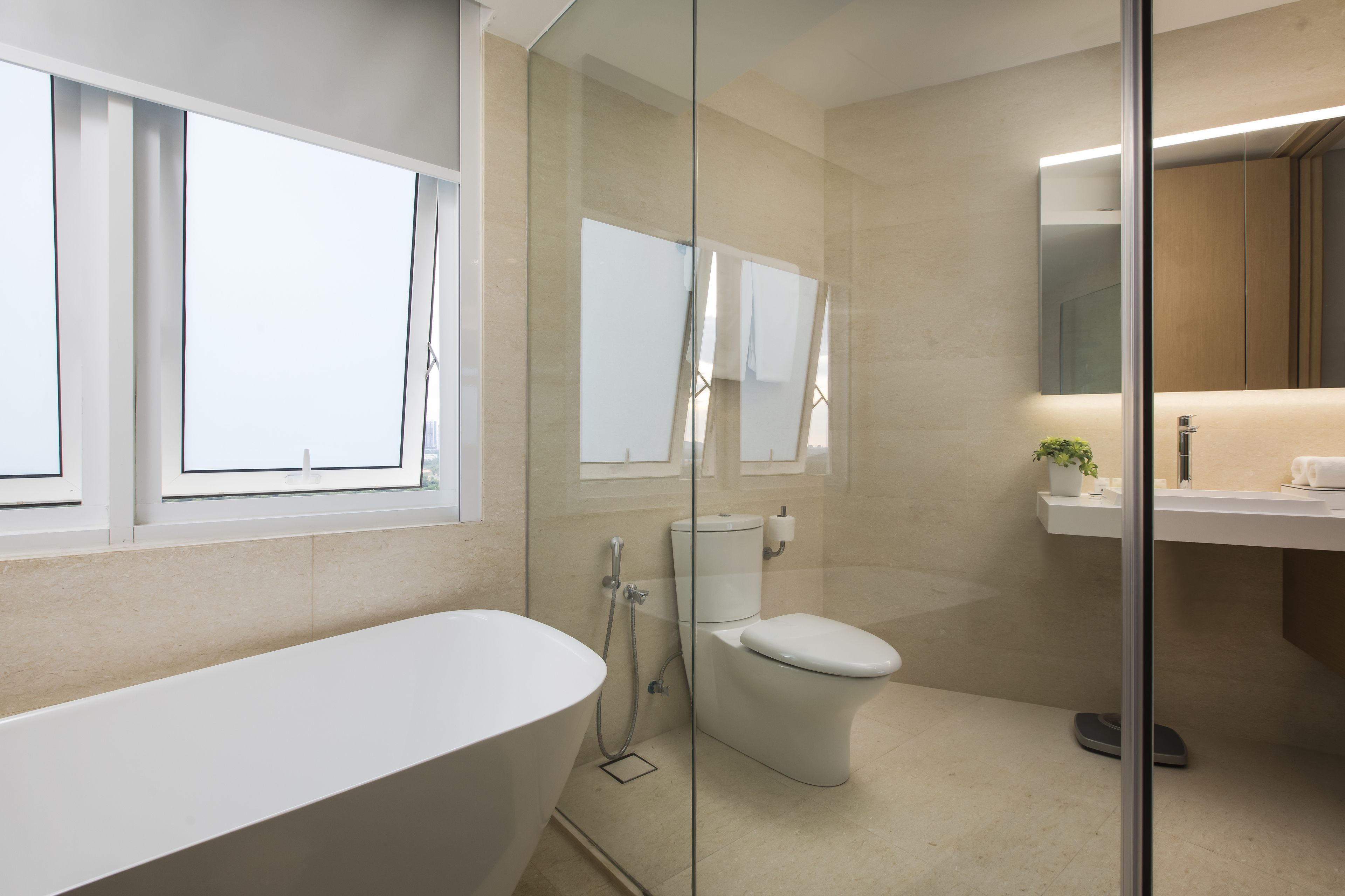 A modern bathroom with a freestanding bathtub, a toilet, and a glass-enclosed shower area.