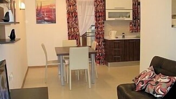 A compact living space with a dining area, kitchenette, and a sofa with patterned cushions. - Apartment in the center of Sliema (Tas-Sliema)