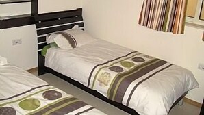 A single bed with a striped bedspread and a headboard. - Apartment in the center of Sliema (Tas-Sliema)