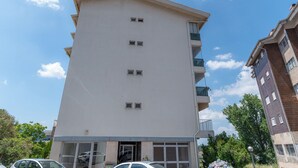 Un edificio de varios pisos con fachada plana, ventanas grandes y balcones.
