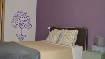 Een slaapkamer met een bed, een nachtkastje en een decoratie aan de muur.