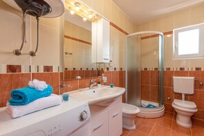 Chuveiro, secador de cabelo, bidê, toalhas de banho