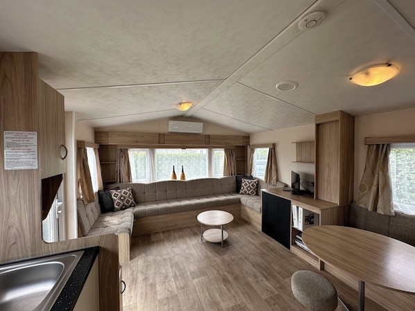 A spacious RV interior with a kitchen area, seating, and a small table.
