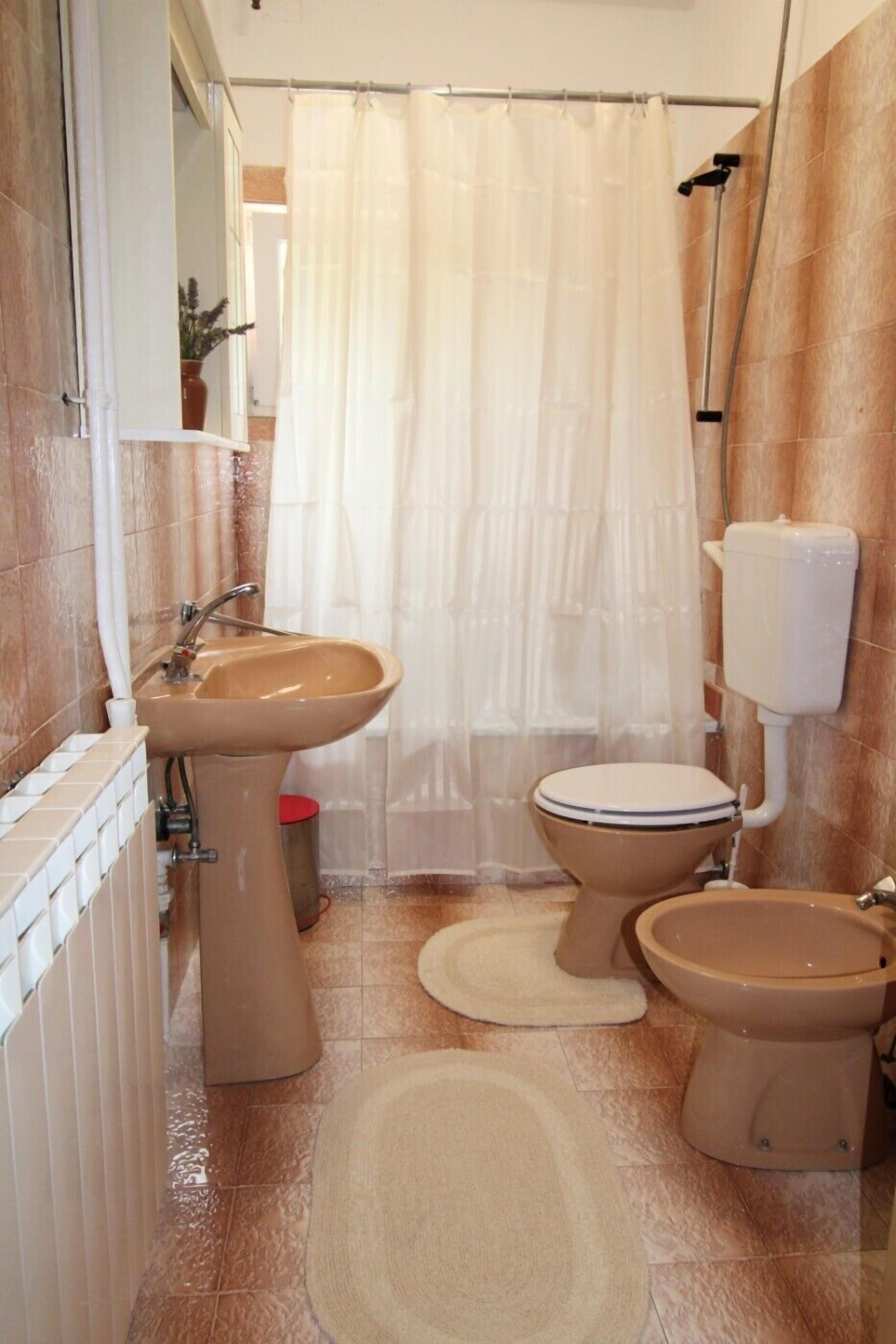 Une salle de bain équipée d’un lavabo, de toilettes et d’un rideau de douche.