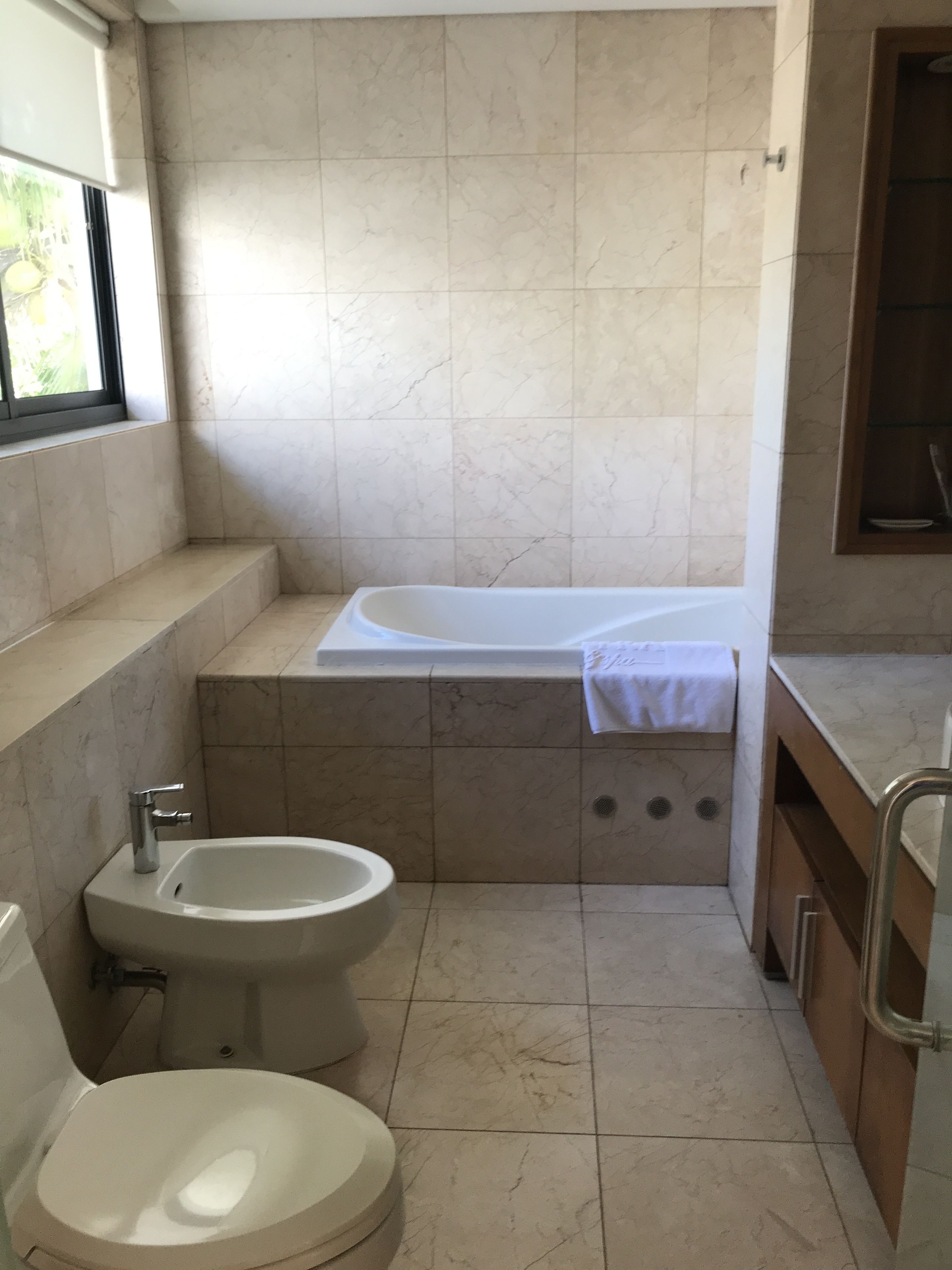 A bathroom with a bathtub, a bidet, and a toilet.