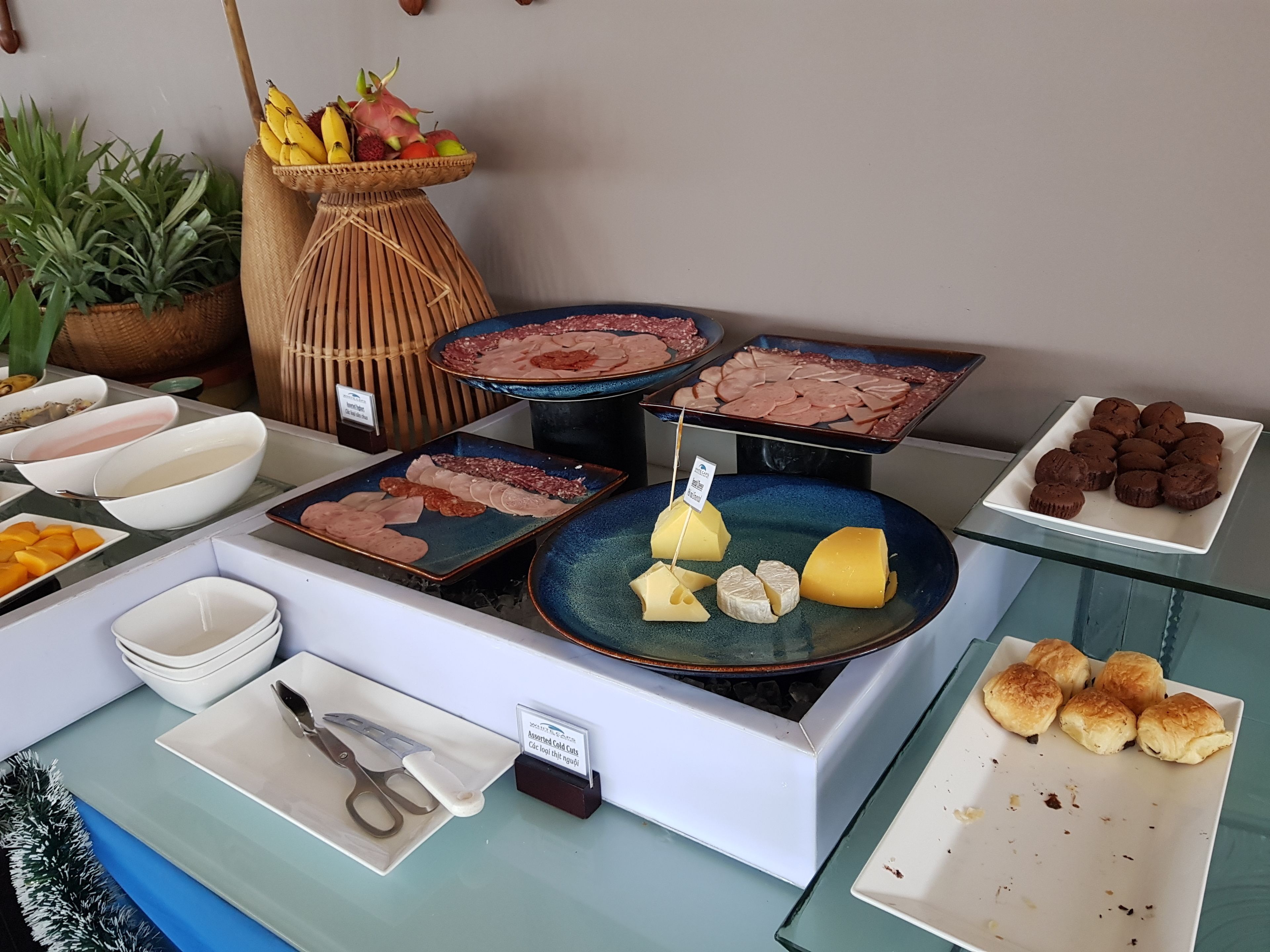 Buffet com diversos alimentos, incluindo carnes, queijos e doces.