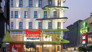 Un hotel de varios pisos con un diseño moderno, que presenta un llamativo letrero 'Maxone Platinum' en la parte superior.