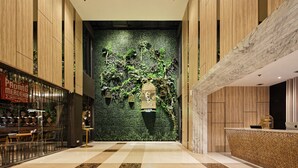 Un vestíbulo moderno con piso a cuadros, paneles de madera y una pared verde con jaulas de pájaros colgantes.