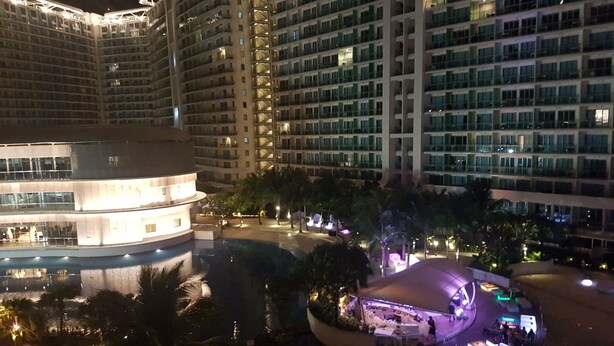 A high-rise hotel with multiple balconies and a pool area. - Santorini 1 Bedroom Condo at Azure Urban Residences (Parañaque)