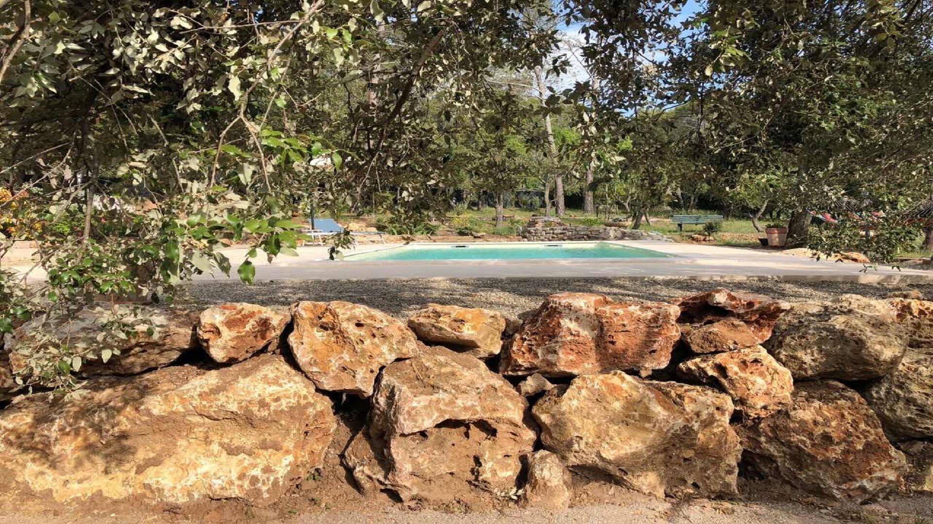 A pool surrounded by rocks and trees.