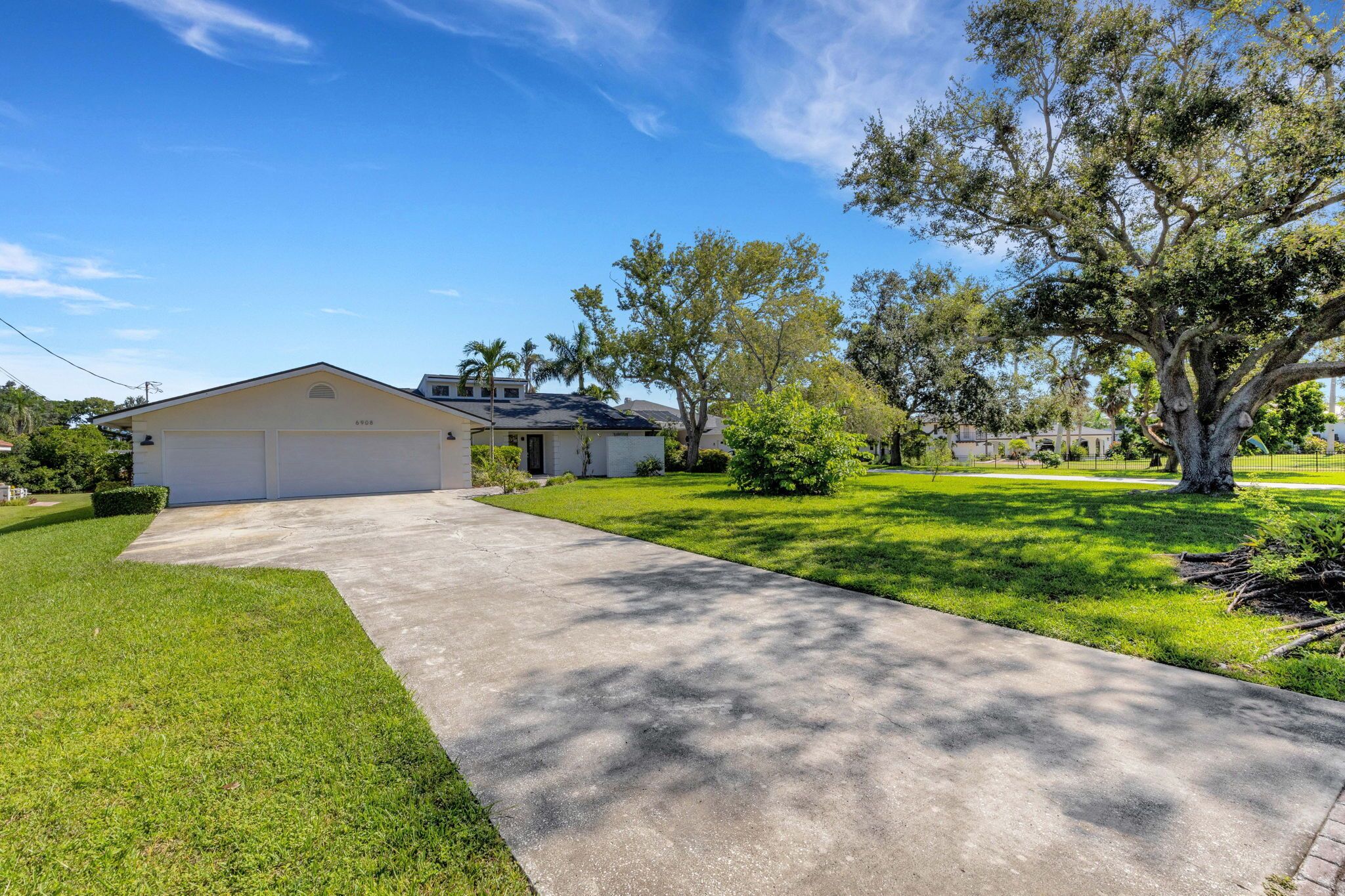 A residential house with a garage, a driveway, and a well-maintained lawn.