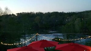 Une vue d’un restaurant avec des parasols rouges et des guirlandes lumineuses.