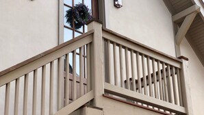Un bâtiment à deux étages doté d’un balcon, d’une fenêtre ornée d’une guirlande et d’une petite lanterne fixée au mur.