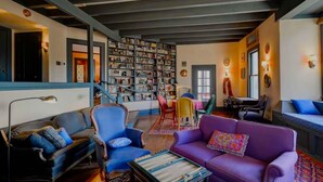 Una sala de estar acogedora con chimenea, estantería y asientos cómodos.