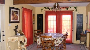Une salle à manger avec une table en bois, des chaises et un lustre.