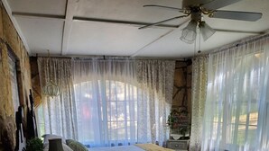 Une chambre avec deux lits, un ventilateur de plafond et une vue sur l’extérieur.