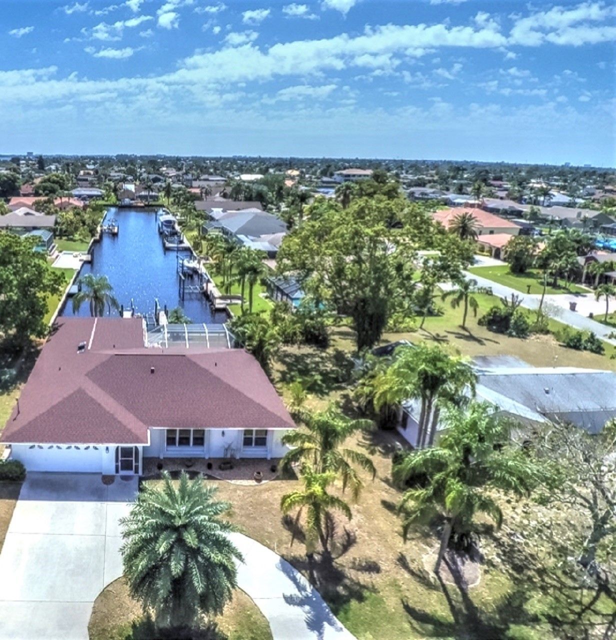 A residential area with a canal view and a house with a red roof.