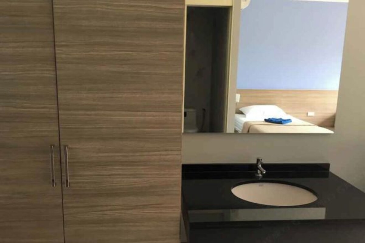 A modern bathroom with a wooden vanity, a sink, and a mirror.