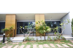 A modern building with a flat roof, large windows, and a paved entrance area with steps. - Phumi Resort (Thep Krasattri)