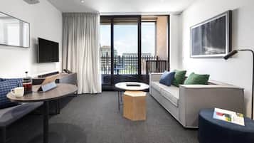 Apartamento ejecutivo, 2 habitaciones | Zona de estar | Una televisión de pantalla plana