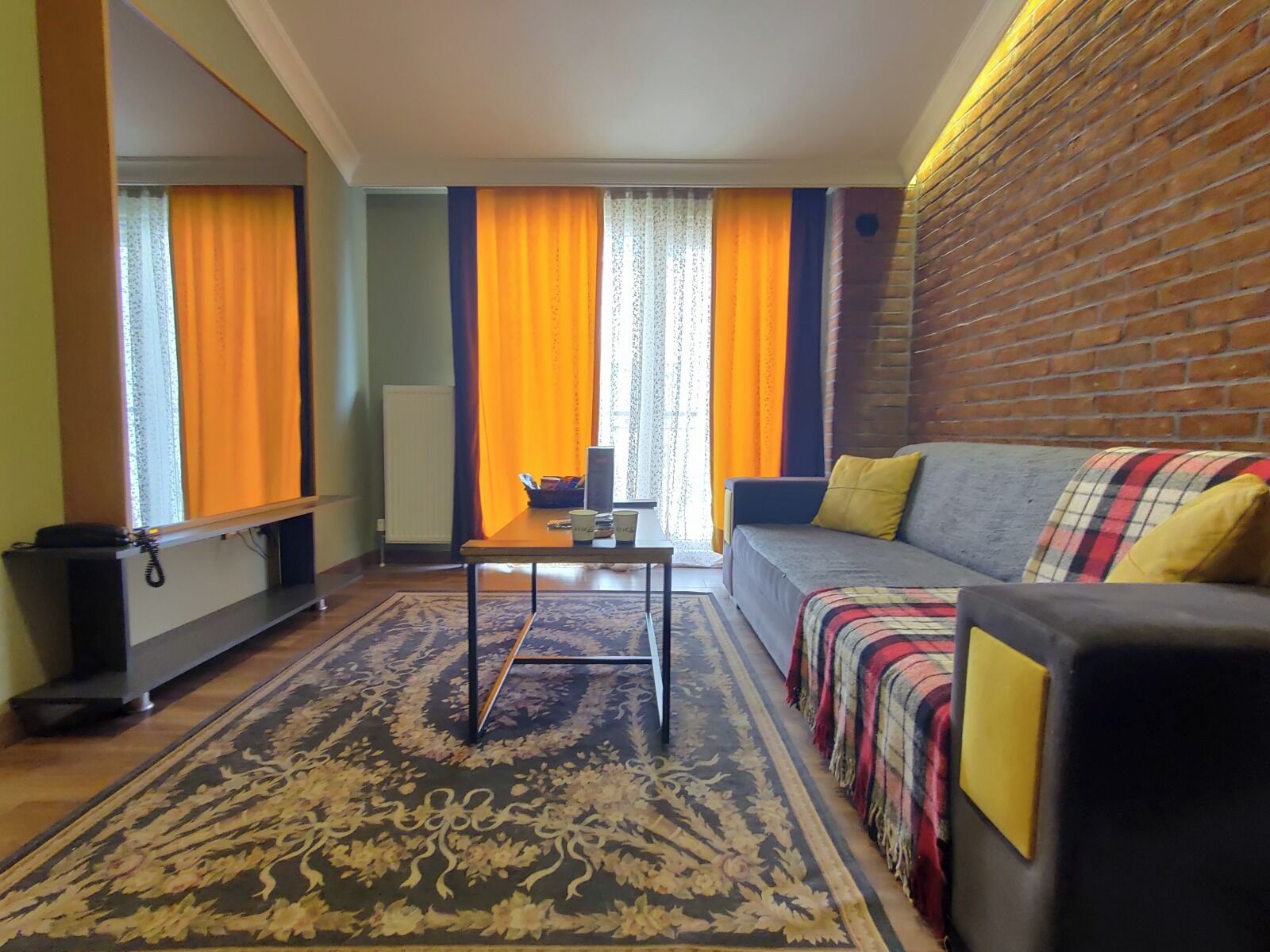 A living room with a sofa, a coffee table, and a patterned rug.