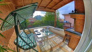 A balcony with a table, chairs, and a hanging umbrella. - Concept House (Ankara)