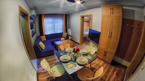 A compact living space with a dining area, sofa, TV, and wardrobe. - Concept House (Ankara)