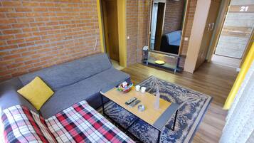 A compact living space with a sofa, a coffee table, and a patterned rug.
