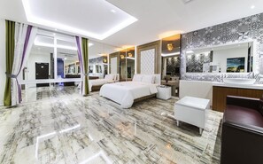 A modern hotel room with a large bed, a sitting area, a vanity, and a bathroom. - Bentley Business Hotel (Gwangju)