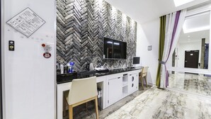Una cuina moderna amb un relleu de punt de petonsina, televisió de pantalla plana i sòl de marbre.