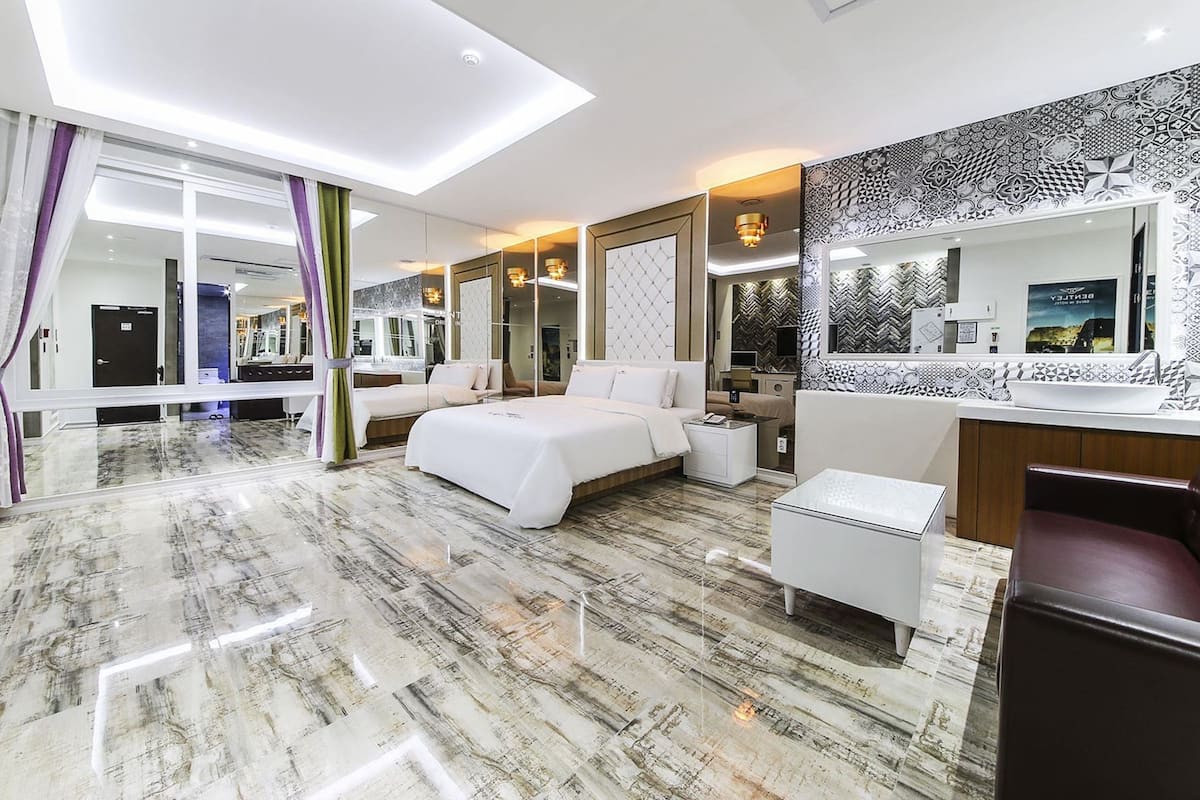 Ein modernes Hotelzimmer mit einem großen Bett, einer Sitzecke, einem Badezimmer und Blick auf die Stadt.