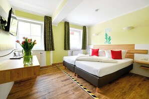 A modern hotel room with a wooden desk, a bed with white and red bedding, and a window with curtains. - Hotel Zum Stern (Werben)