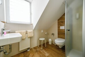A modern bathroom with a white sink, toilet, and shower. - Hotel Zum Stern (Werben)