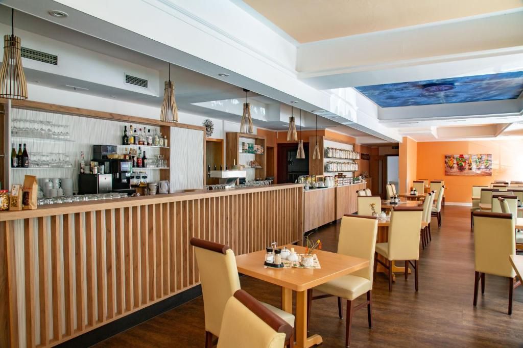 A restaurant with a bar area, wooden paneling, and a ceiling mural.