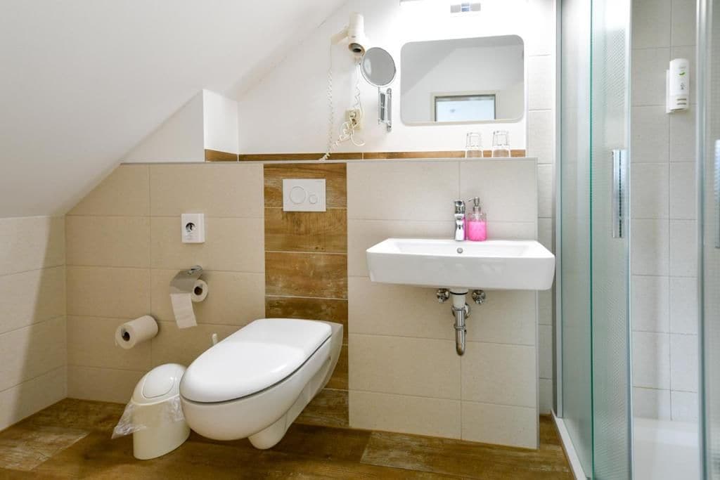A modern bathroom with a toilet, sink, and shower.