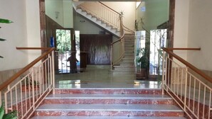 A marble staircase with wooden railings leading to a second-floor landing. - Dante 58 (Palermo)