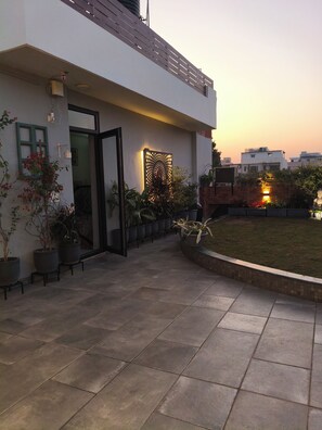 A modern building with a tiled patio, potted plants, and a decorative wall. - vandanas bed and breakfast (New Delhi)