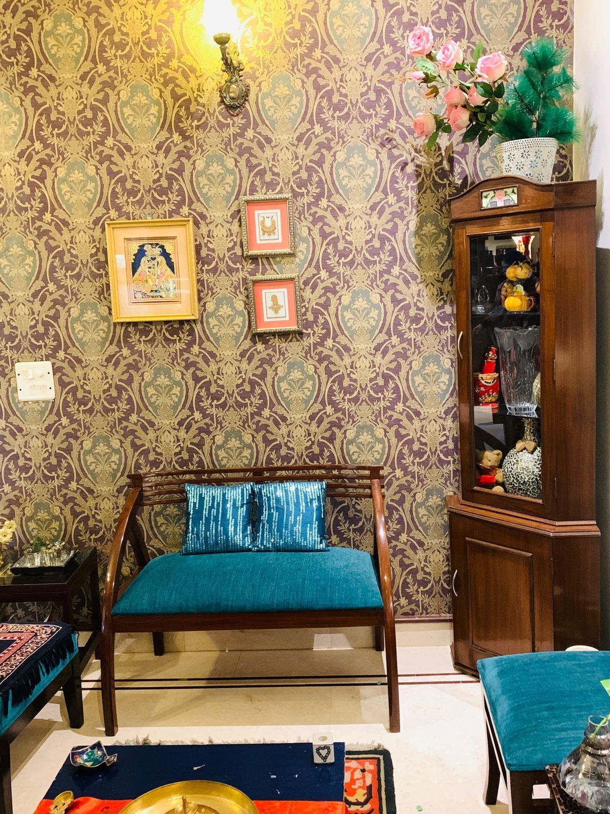 A traditional room with a wooden bed, patterned wallpaper, and a cabinet with decorative items.