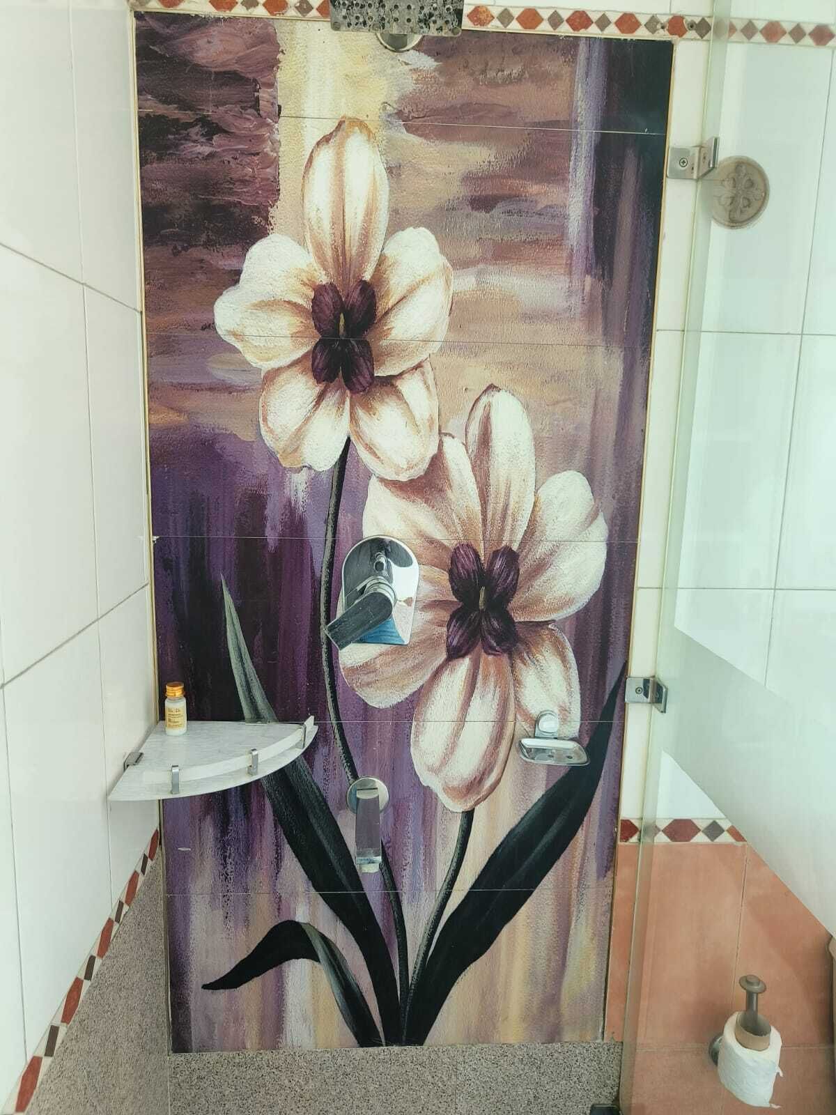 Une salle de bain avec un grand décor mural représentant des motifs floraux, un lavabo et des toilettes.