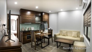 Een knus woongedeelte met een kitchenette, eethoek en een bank.