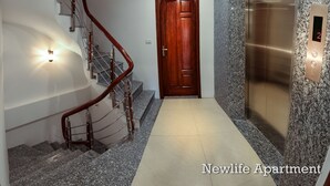 Een modern appartement met een spiltrap, een houten deur en een granieten lift.