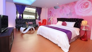 A modern bedroom with a bed, a sofa, a TV, and a decorative wall. - Dania Garden (Luodong)