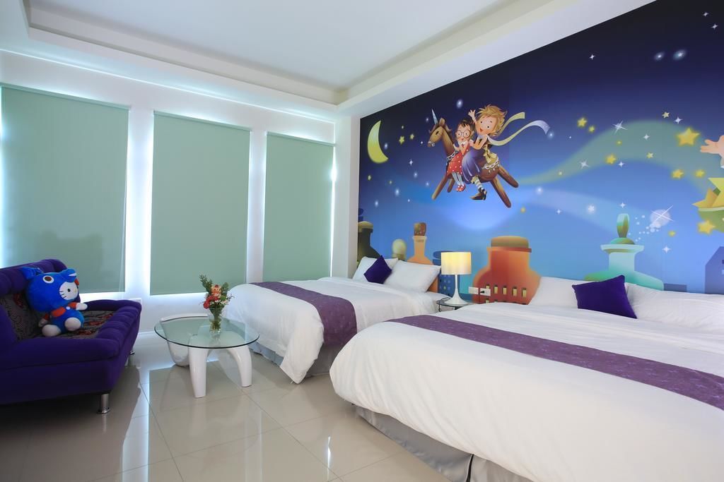 Habitación de hotel con dos camas, una mesita de vidrio, una silla morada y un mural con una escena nocturna de estrellas y una luna creciente.