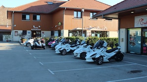 Ein Hotel mit Restaurant, eine Reihe geparkter Motorräder und ein Schild für ein Geschäft in der Nähe.