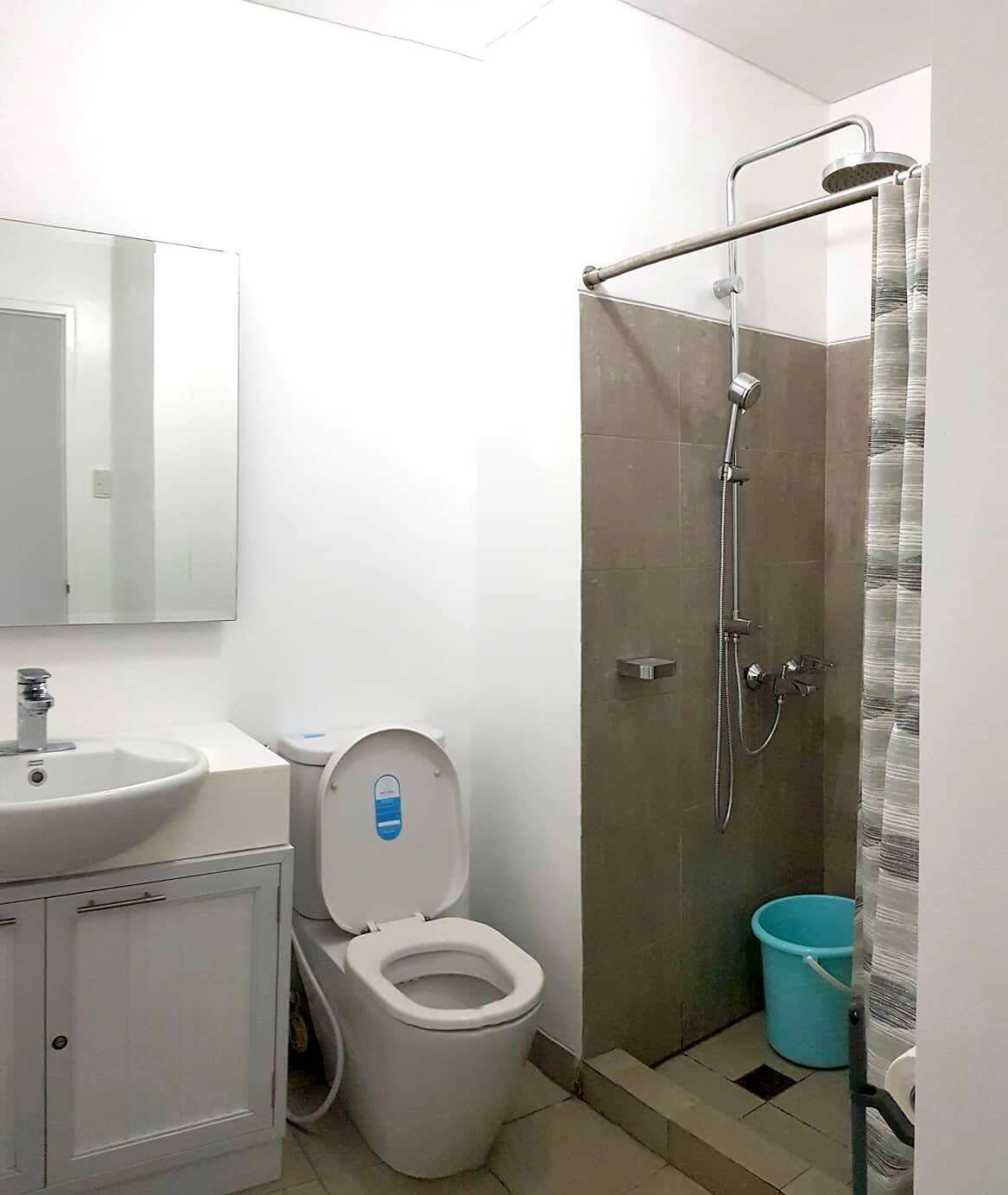 Un baño con inodoro, lavamanos y ducha.