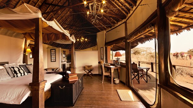 A room with a bed, a desk, and a view of the outside. - Tawi Lodge (Amboseli)