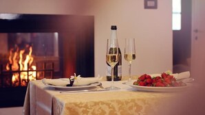 A table set for two with a bottle of white wine and glasses, a plate of strawberries, and a white napkin. - Bed & Breakfast Korta Gira (Porec)